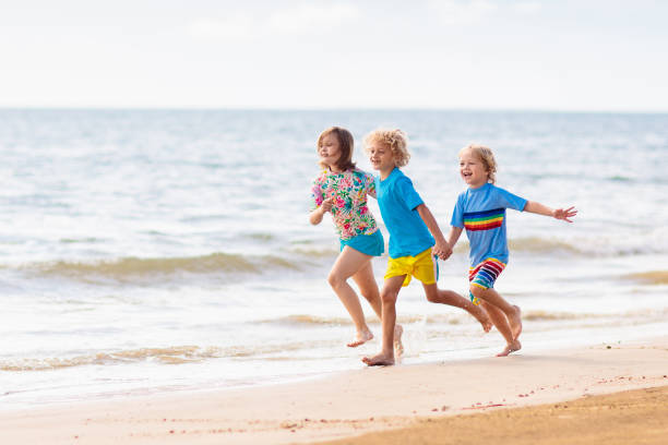 istock Kids playing on beach. Children play at sea. 1207110816