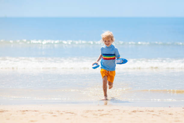 istock Kids playing on beach. Children play at sea. 1207111103