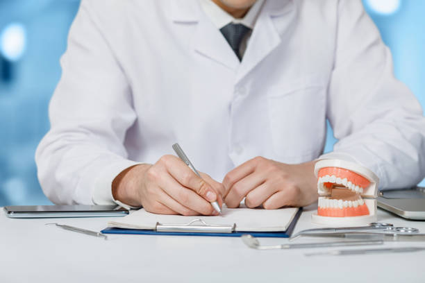 istock Dentist writes a medical history at a table o. 1207112279