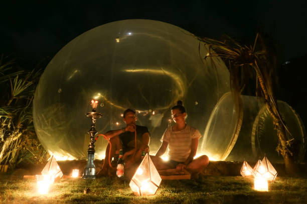 istock Badung - A couple sitting in front of a bubble hotel 1207112793