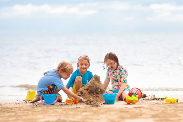 istock Kids playing on beach. Children play at sea. 1207113087