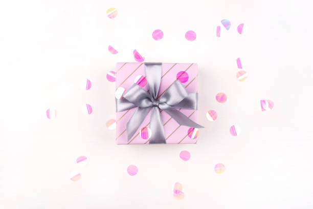 istock One gift boxe with bow and confetti on a white background. 1207113813