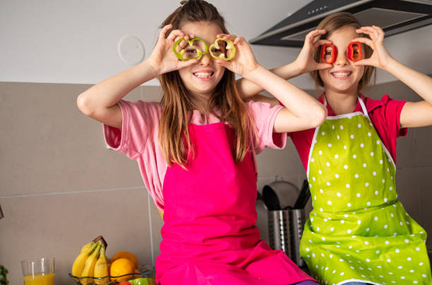 istock Two cute girls having fun in the kitchen 1207114332