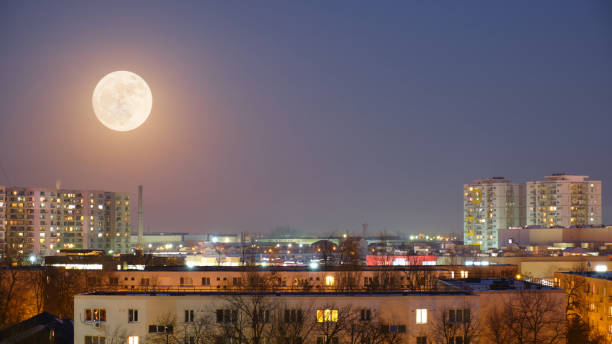 istock Full moon rise at blue hour over city scape. Copy space. 1207115614