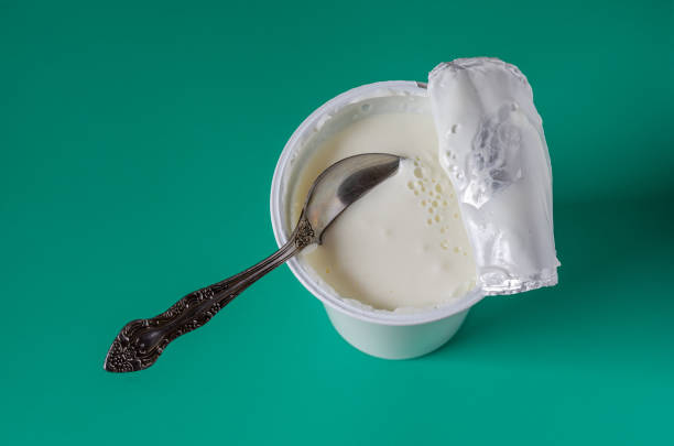 istock Yogurt with a spoon in a plastic glass. 1207115651