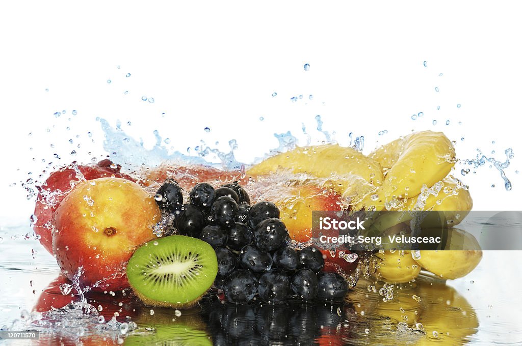 A variety of fruits in a splash of water Pure fruit in a spray of water isolated on a white background. Banana Stock Photo