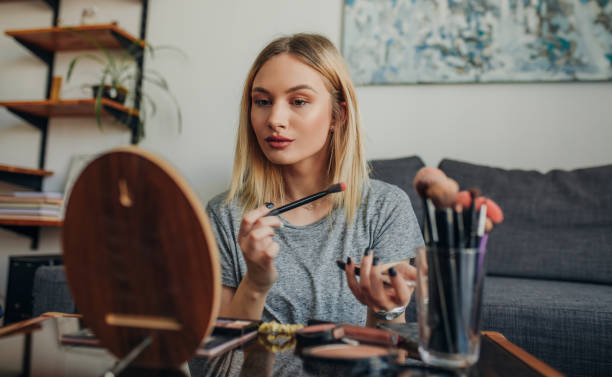 istock Young woman in her apartment doing her make up 1207120400