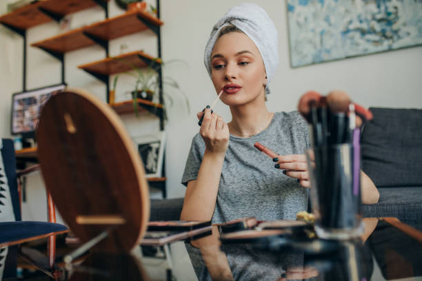 istock Young woman in her apartment doing her make up 1207121067