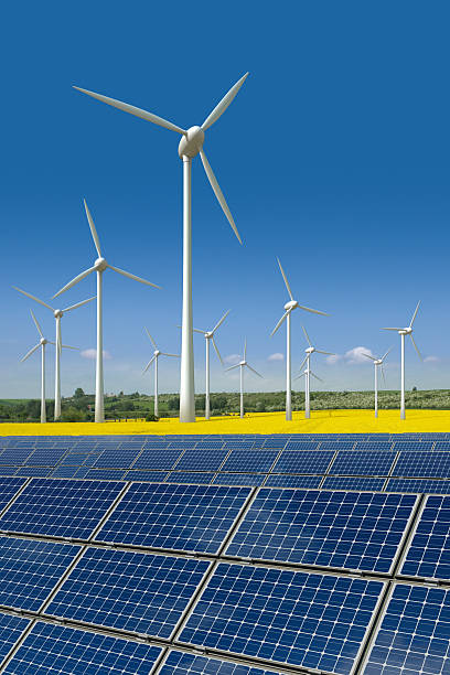 Wind turbines and solar panels in a rapeseed field stock photo