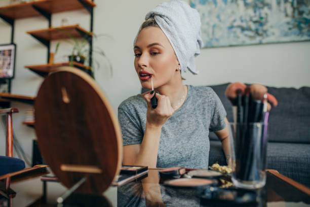 istock Young woman in her apartment doing her make up 1207121963