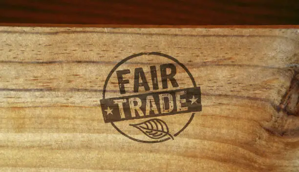 Fair Trade stamp printed on wooden box. Ethical business, green trade, sustainable economy and environmental care concept.