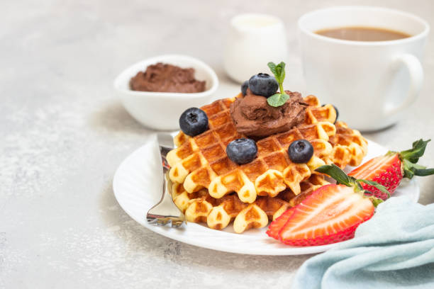 istock Plate with belgian waffles with chocolate sauce, berries and mint on a light gray background. Breakfast or lunch. 1207123158