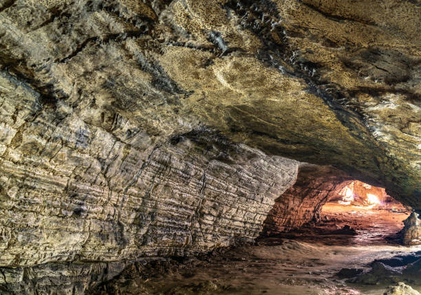 istock View inside the ancient cave with stone walls with additional lighting. Texture of a stone wall in a cave. 1207124521