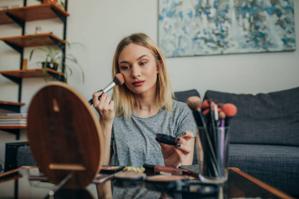 istock Young woman in her apartment doing her make up 1207124790