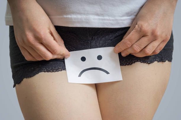 concepto de problemas vaginales o menstruales. la joven sostiene papel con sos por encima de la entrepierna. - thrush fotografías e imágenes de stock