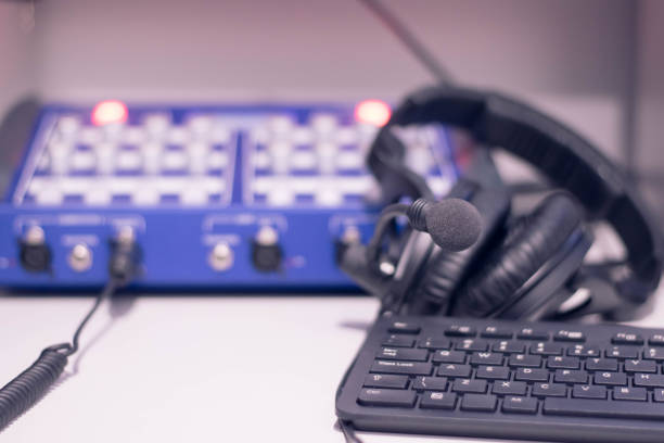 istock Studio time. Close-up headphones  with other professional audio studio equipments. Microphone for podcasts and studio headphones on a PC keyboard on a black background, horizontal frame stock photo. 1207130299