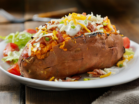 Loaded, Twice Baked Sweet Potato with Bacon, Cheese, Green Onions and Sour Cream and a Side Salad