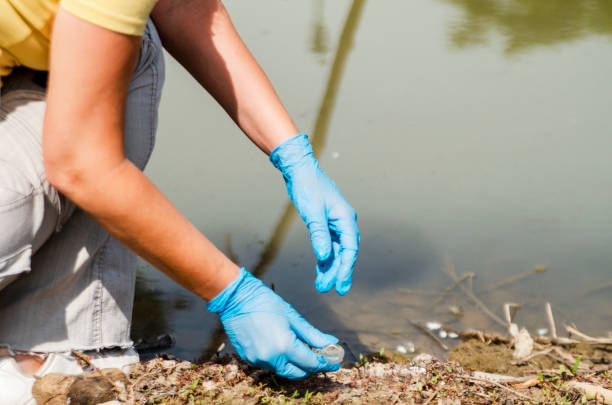 istock Young woman ecologist on the river shore 1207132829