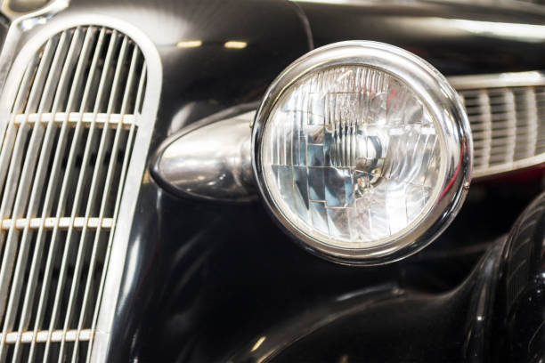 istock Headlight lamp vintage car. Headlight lamp vintage classic car. Front part with the headlight retro car closeup. 1207135522