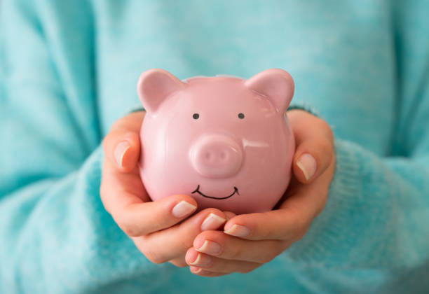 Female hand holding piggy bank Female hand holding piggy bank personal loan stock pictures, royalty-free photos & images