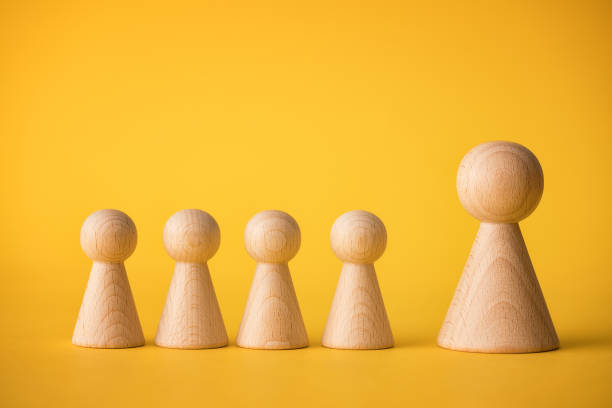 Wooden figures on yellow background
