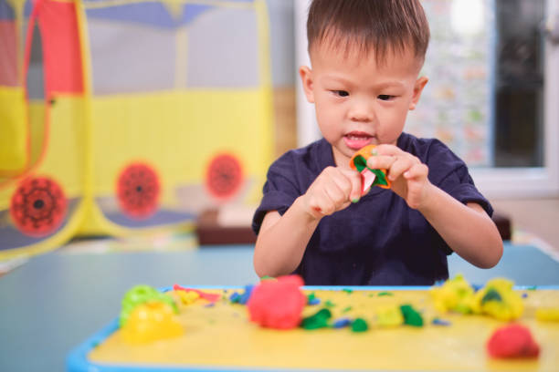 asiatique 2 - 3 ans enfant en bas âge de garçon ayant l’amusement jouant l’argile colorée de modélisation / pâte de jeu à la maison, jouets éducatifs pour l’enfant - asian cuisine photos photos et images de collection