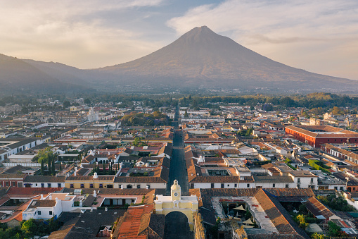 Areal photo of the historic old town of Antigua in Guatemala, surrounded by their active volcanos.