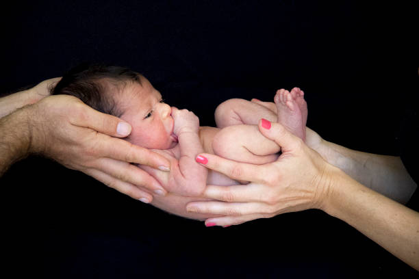 istock Parents Holding Infant in Arms 1207144093