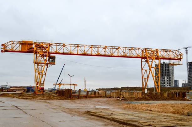 wysoka heavy heavy metal iron nośny konstrukcja stacjonarna przemysłowa potężny suwnica bramowa typu mostu na podporach do podnoszenia ładunków na nowoczesnym placu budowy budynków i domów - nośny zdjęcia i obrazy z banku zdjęć