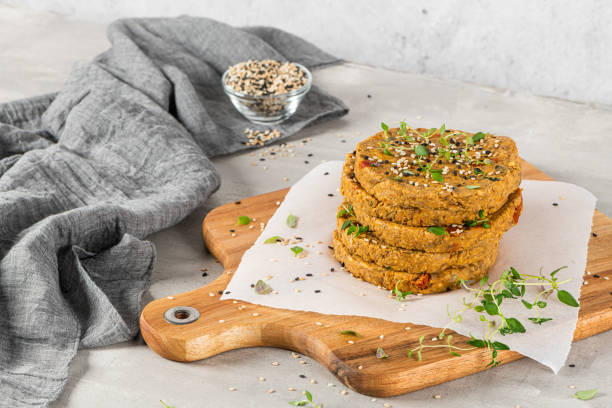 istock Raw veggie burger with lentils, vegetables and thyme leaves on kitchen countertop. 1207146627