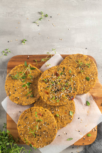 istock Raw veggie burger with lentils, vegetables and thyme leaves on kitchen countertop. Top view. Flat lay 1207146651