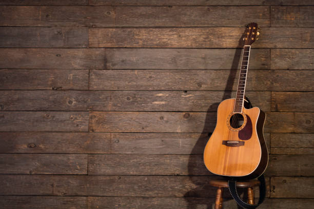 istock Guitar on stage leaning against barn wood 1207146656