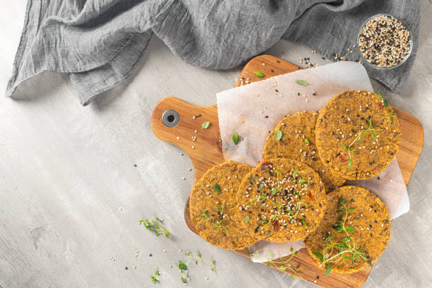 istock Raw veggie burger with lentils, vegetables and thyme leaves on kitchen countertop. Top view. Flat lay 1207146874