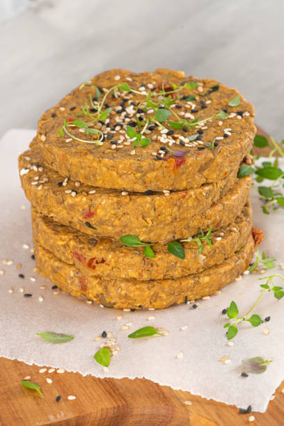 istock Raw veggie burger with lentils, vegetables and thyme leaves on kitchen countertop. 1207146897