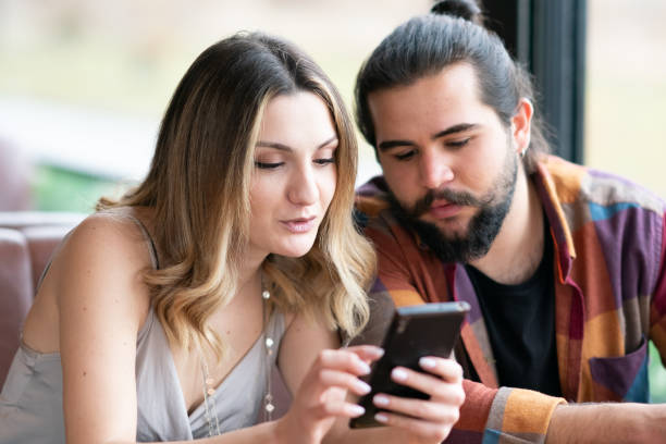 istock Man and woman looking at the phone screen 1207149898