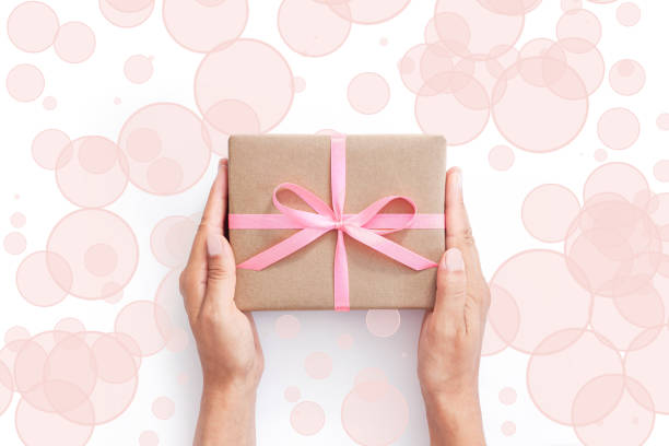 istock Female hands holding present box or gift box package in craft paper 1207151216