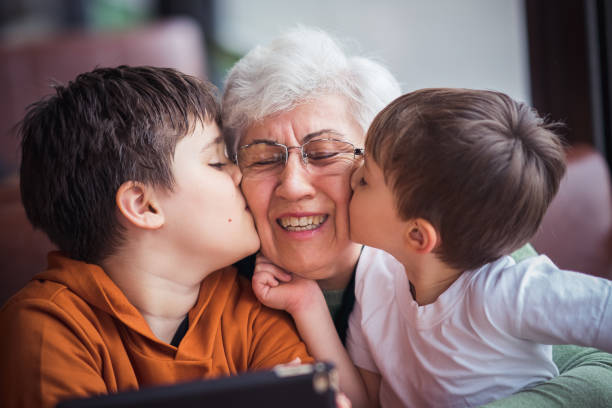 istock Grandsons kissing their grandma. 1207152001