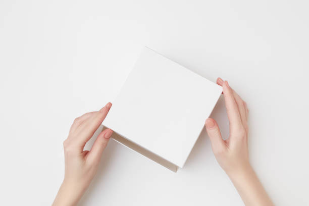 istock Mock up of white present box in women's hands on the white background 1207153410