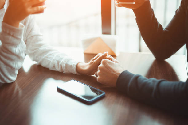 istock Crop couple holding hands gently on cafe table 1207153458