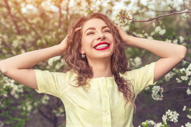 istock Cheerful woman rumpling hair in spring garden 1207153475