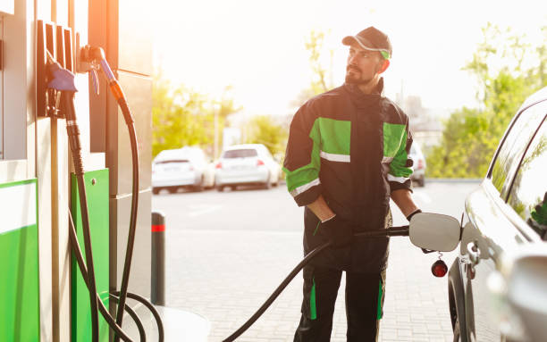 istock Bearded worker refueling car on station 1207153500