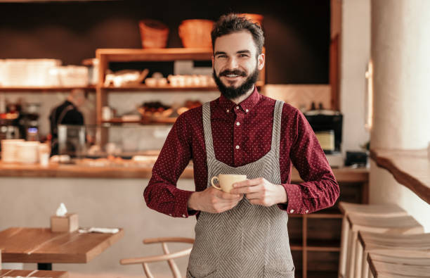 istock Bearded barista with cup in cafe 1207153548