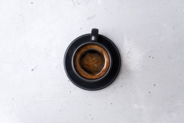 Cup of coffee on grey background, top view