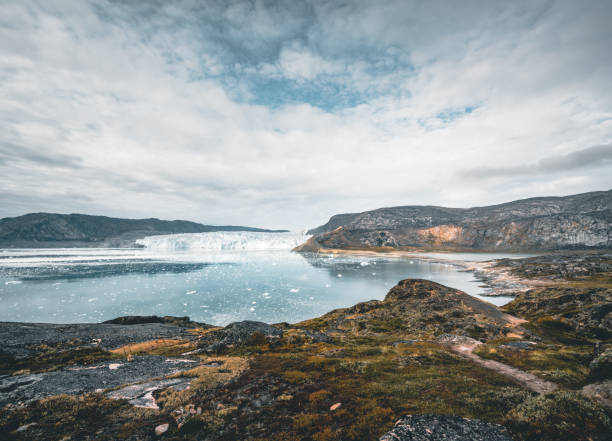 Panoramic image of Camp Eqi at Eqip Sermia Glacier in Greenland. nature landscape with lodge cabins. Midnight sun and pink sky. Tourist destination Eqi glacier in West Greenland AKA Ilulissat and Jakobshavn Glacier. Heavlly affected by Global Warming. Photo taken in Greenland imagen panorámica del campamento eqi en el glaciar eqip sermia en groenlandia. paisaje natural con cabañas de alojamiento. sol de medianoche y cielo rosa. destino turístico glaciar eqi en groenlandia occidental también conocido como ilulissat y glaciar