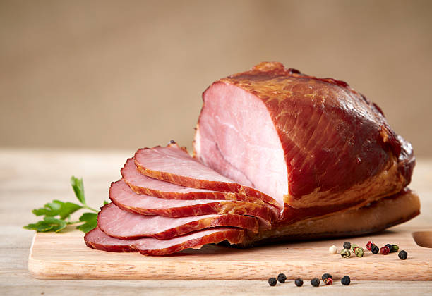 istock Partially sliced smoked ham on wooden cutting board 120715858