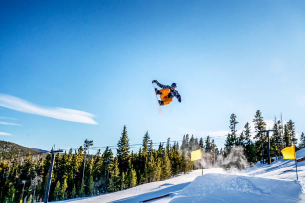 un joven snowboarder masculino saliendo de un salto en una estación de esquí en colorado en un día soleado - big air fotografías e imágenes de stock
