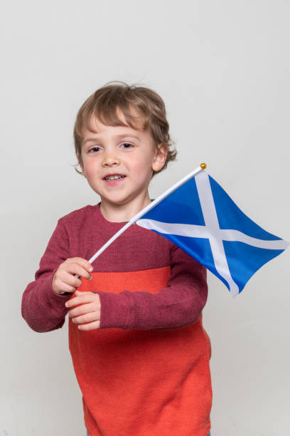 istock Smiling caucasian Child boy looking at the camera holding a Scottish flag 1207163421