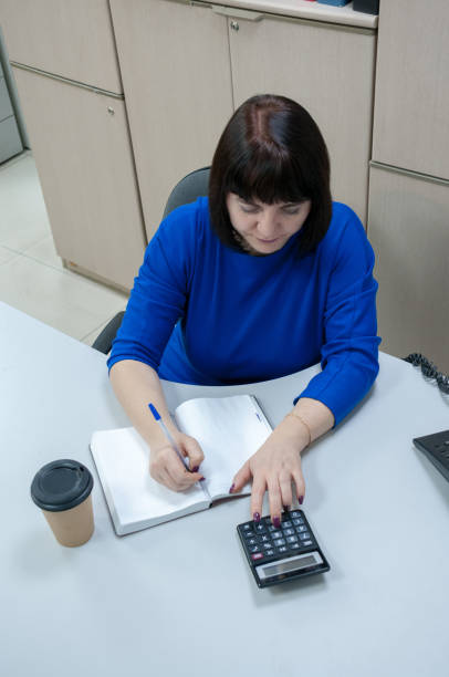 istock The accountant counts on a calculator and writes in a notebook at the table 1207166290