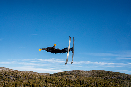 A confident Freestyle skier catching air off a jump at Eldora ski area in Colorado on a clear day