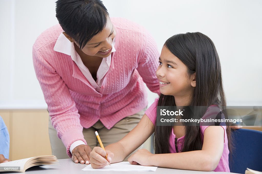 Profesor ayudando a niños de escuela primaria en clase - Foto de stock de Maestro libre de derechos